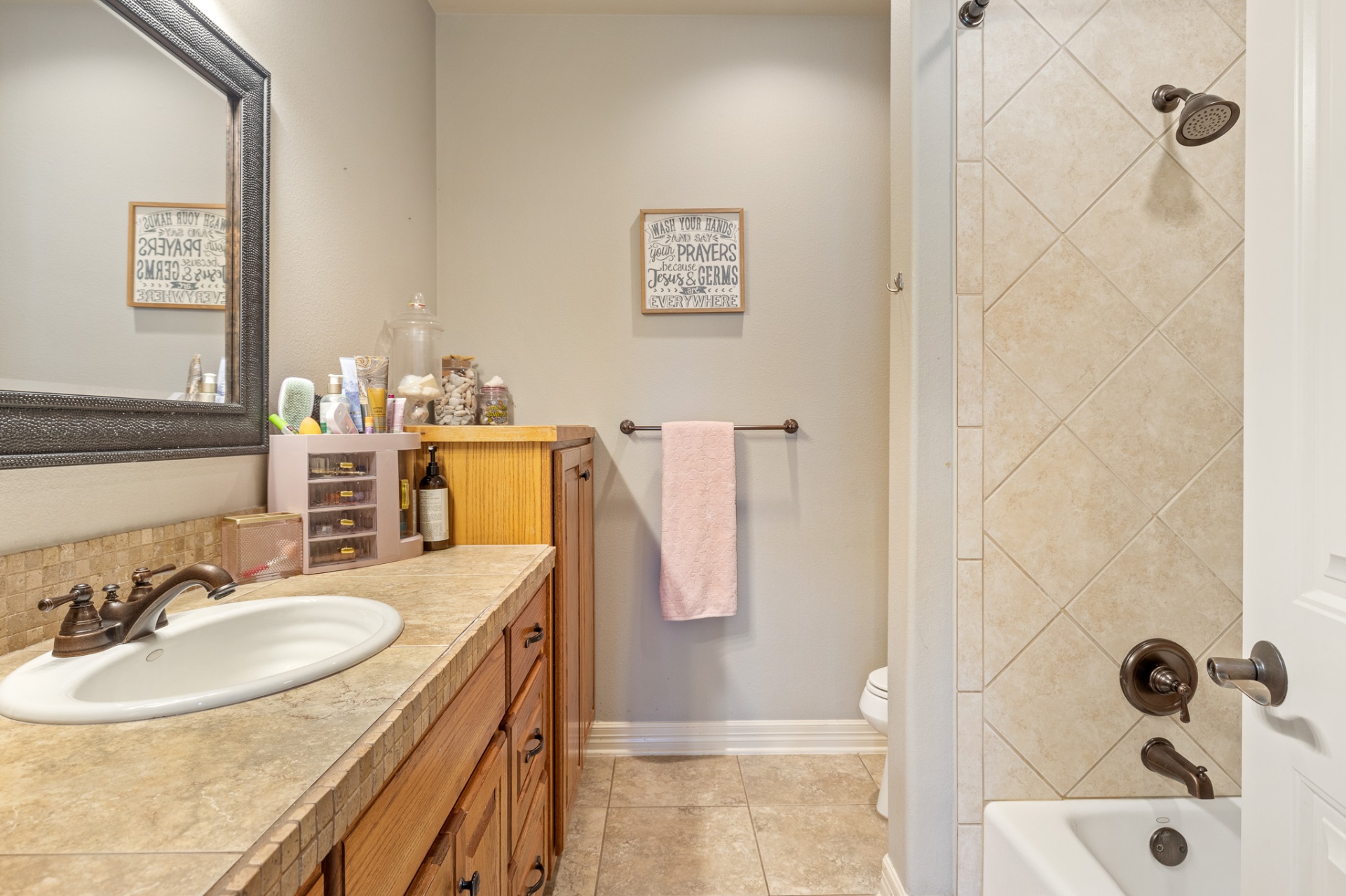 Secondary bathroom with wood vanity and tile shower
