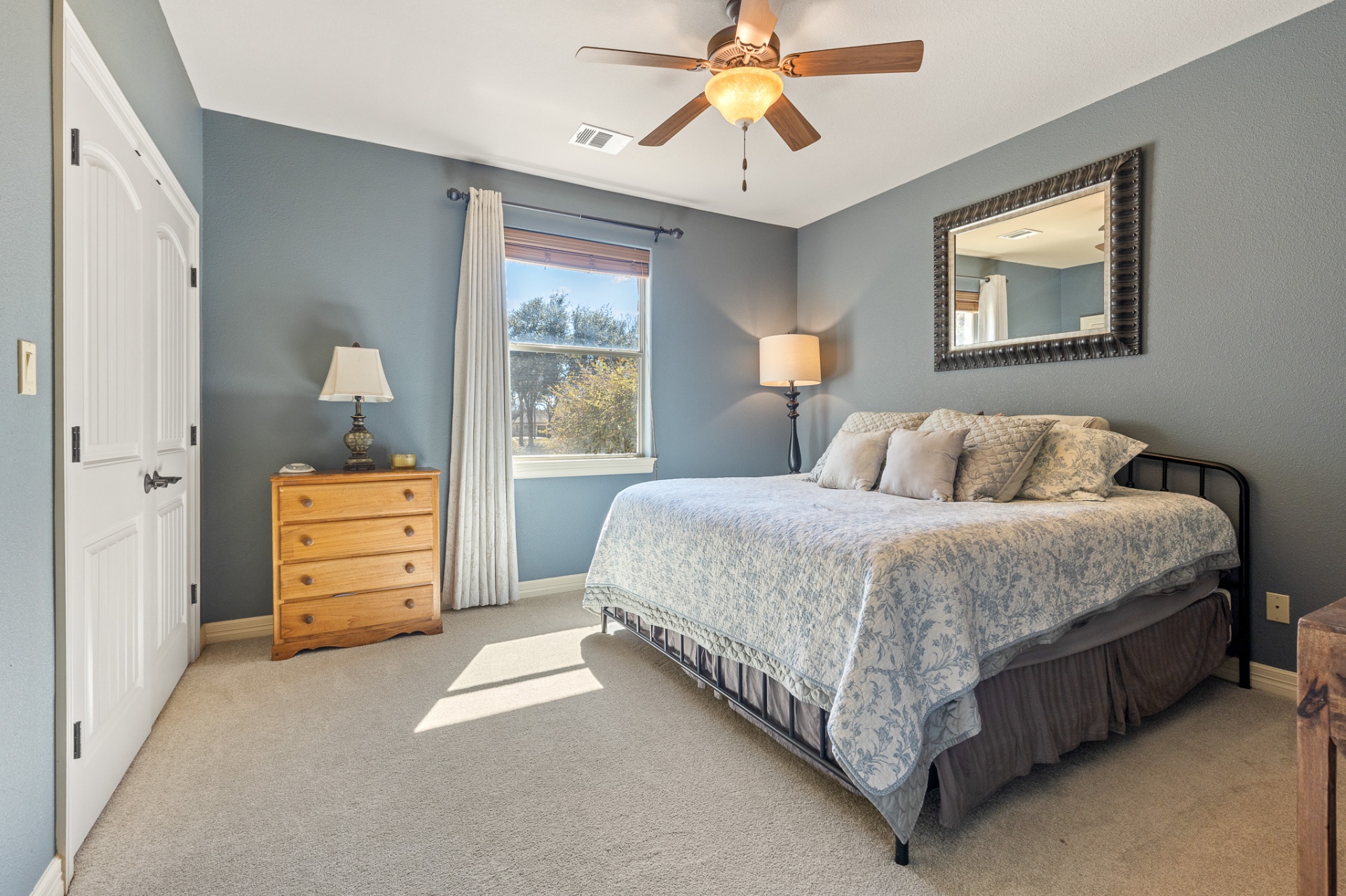 Guest bedroom with ceiling fan and double closet doors