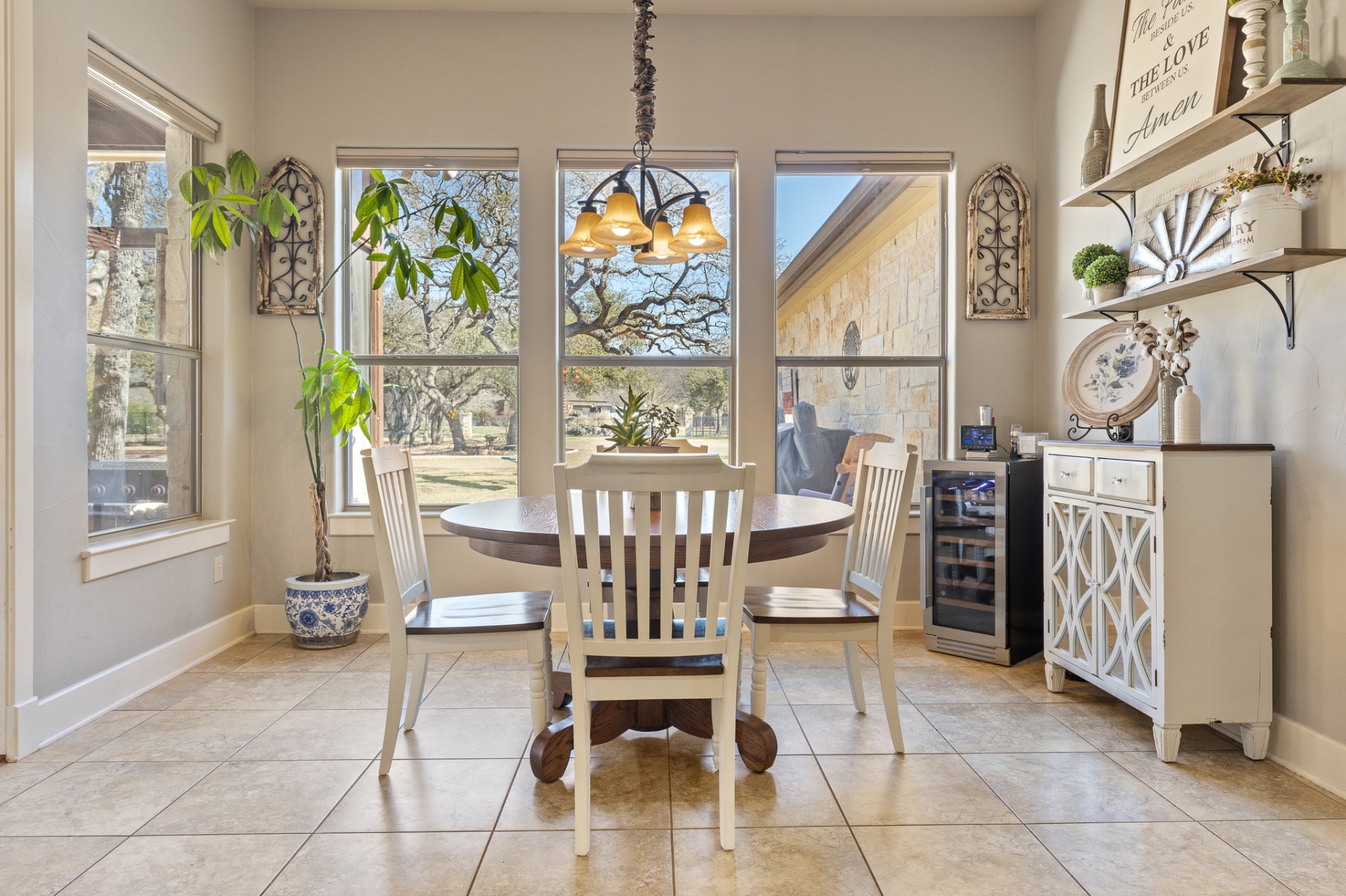 Breakfast nook with chandelier and wine cooler overlooking oak trees
