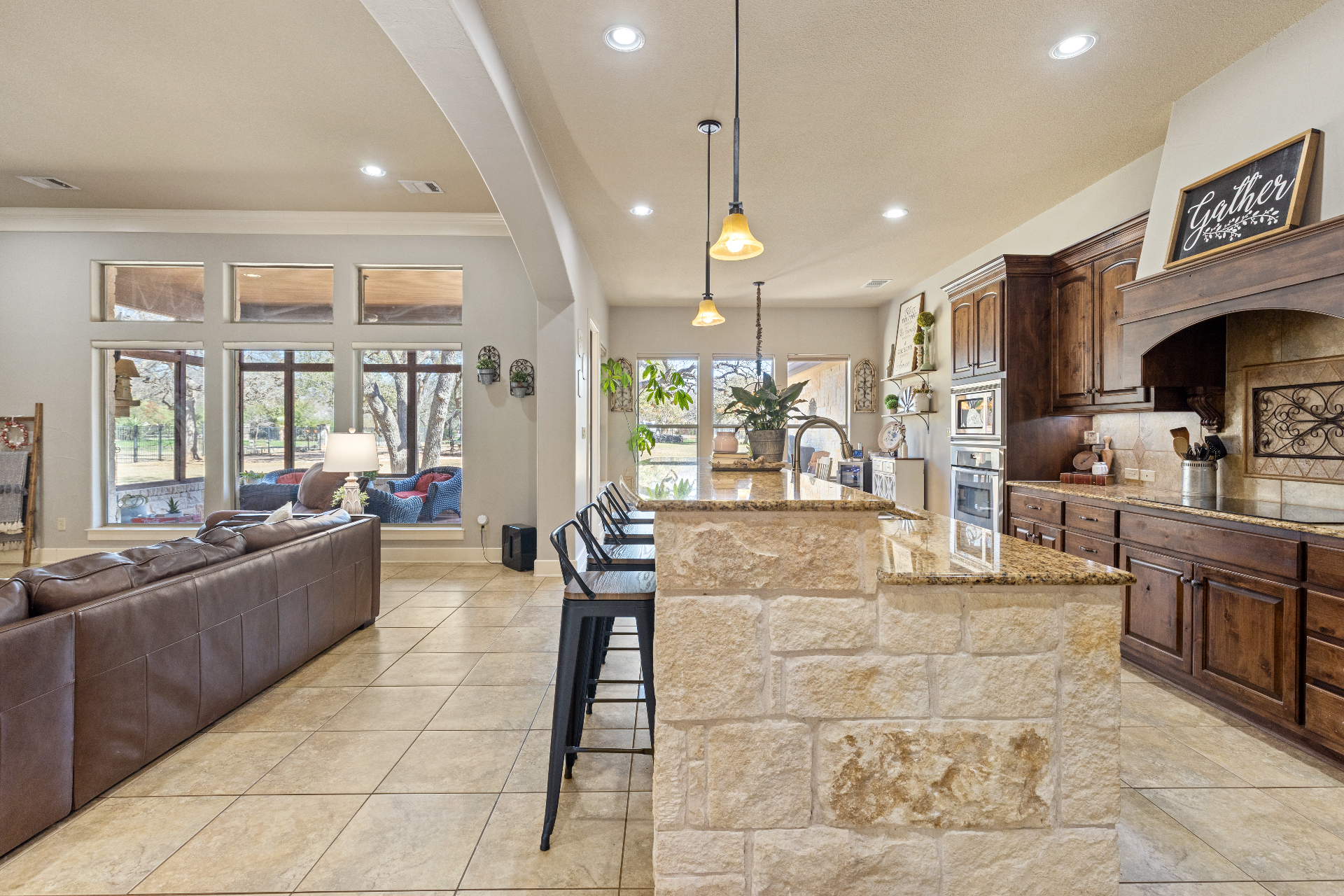 Wide view of kitchen open to living area with stone breakfast bar