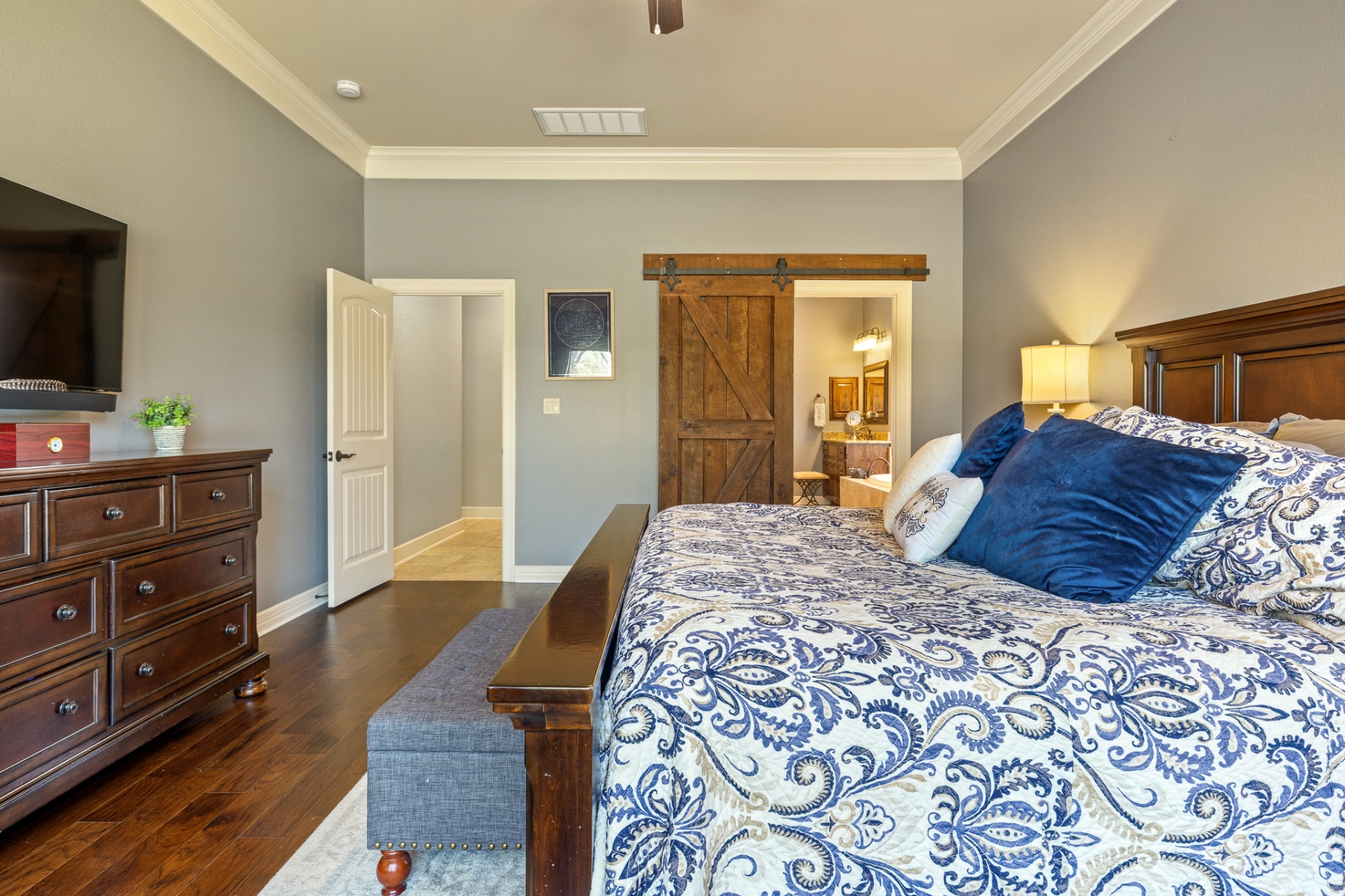 Primary bedroom with rustic barn door to en-suite bathroom