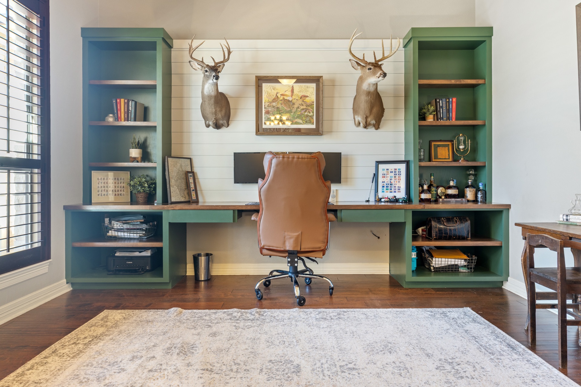 Home office with custom built-in desk, shiplap accent wall, and shelving