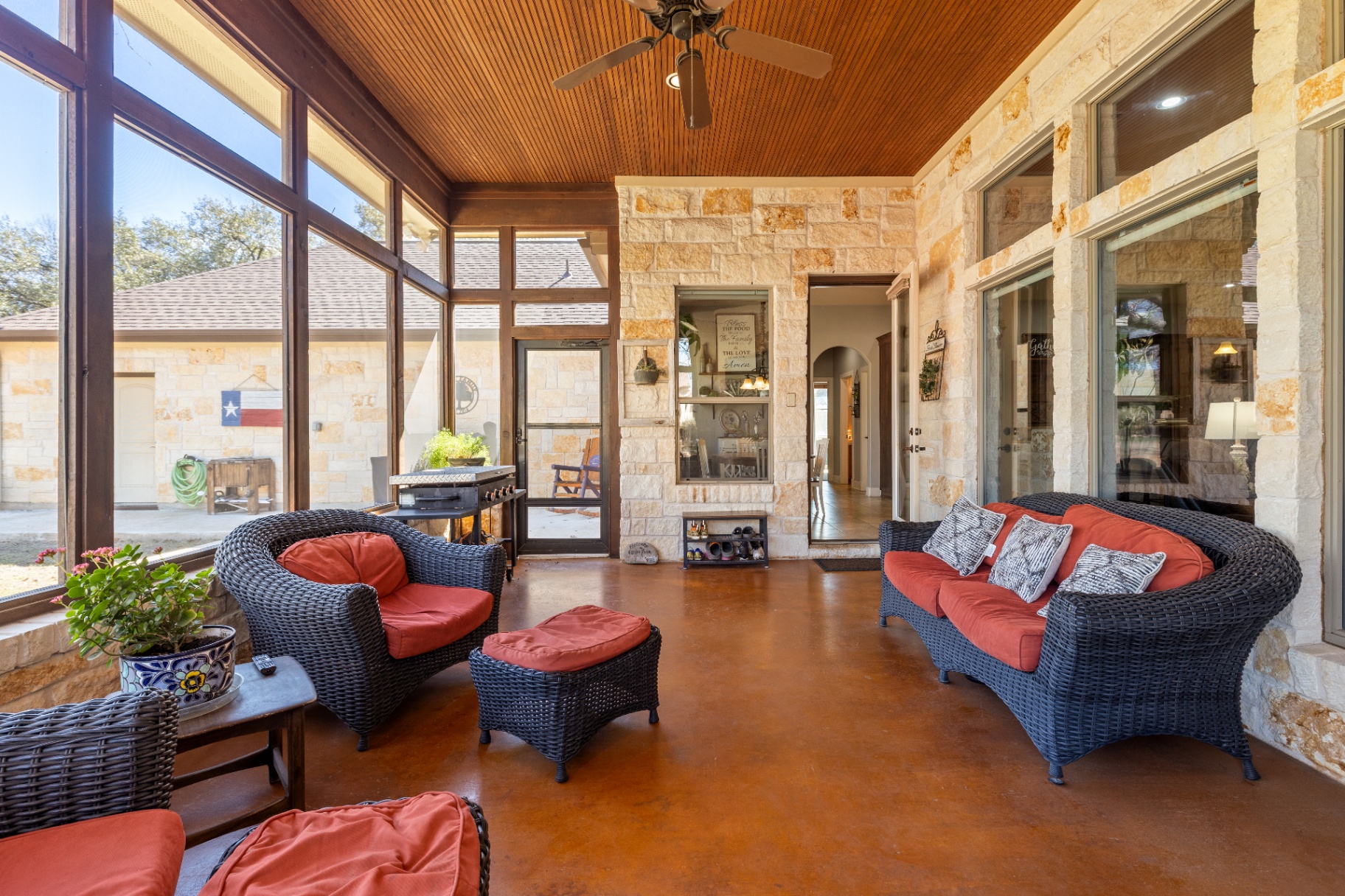 Screened patio with wicker furniture and stained concrete floors